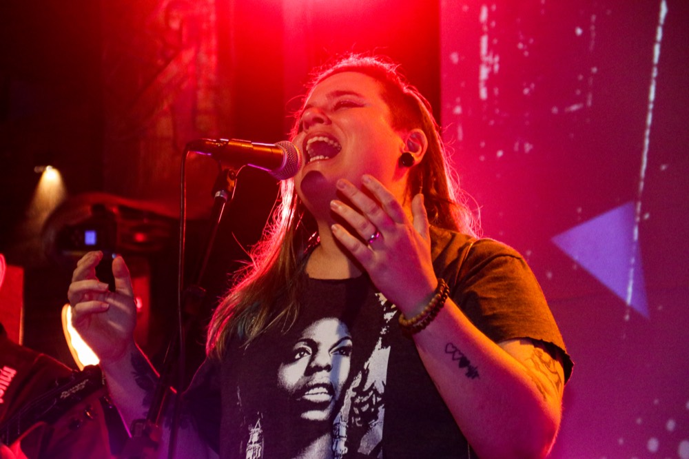 Cantora no palco do Chiquinha Gonzaga Fest sob luz rosa